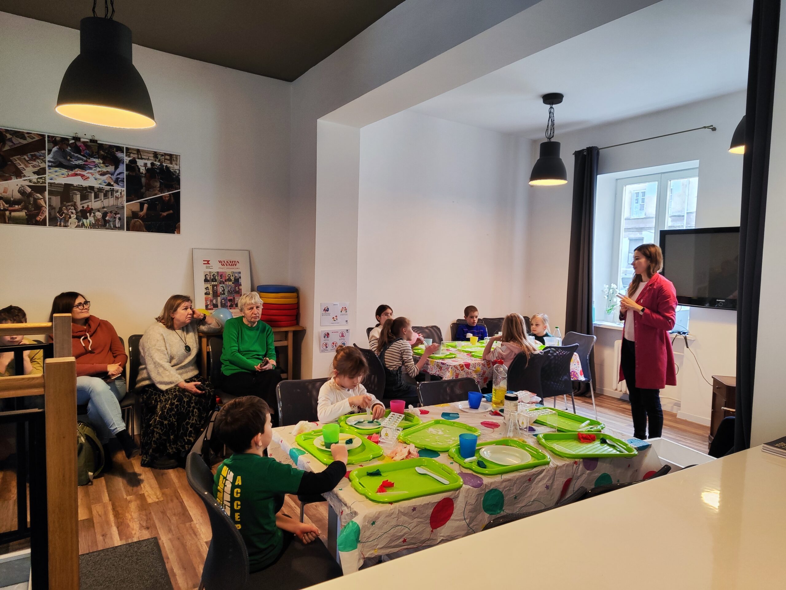 Zdjęcie z warsztatów pod tytułem „Eksperymenty Stasia Taczaka, czyli chemia dla każdego ejbra”. Na fotografii widzimy dzieci biorące udział w warsztatach chemicznych.